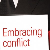 man with a sign 'embracing conflict'